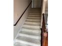 Carpeted staircase with wood railing leading to the upper level of the home at 6420 Phillips Pl, Lithonia, GA 30058