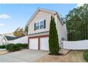 Two-story home featuring a two-car garage, complemented by manicured landscaping and a privacy fence at 158 Oak Grove Pl, Acworth, GA 30102