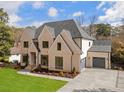 Charming brick home boasts manicured landscaping, a spacious driveway, and attached two-car garage at 4895 Lansbury Dr, Atlanta, GA 30342