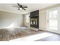 Bright living room with a stone fireplace, ceiling fan, wood-look flooring, and a door to the backyard at 5063 White Sw Blvd, Mableton, GA 30126