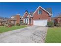Charming two-story brick home with a well-manicured lawn and a paved driveway at 2020 Stockton Walk Ln, Snellville, GA 30078