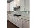 Modern kitchen with white cabinets, stainless steel range hood, gas cooktop, and tile backsplash at 7260 Bluewater Ln, Douglasville, GA 30135