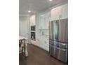Spacious kitchen showcasing stainless steel refrigerator, built-in oven, and large kitchen island at 7260 Bluewater Ln, Douglasville, GA 30135