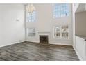 Bright living room featuring a fireplace, hardwood floors, and large windows at 114 Highgrove Pl, Mcdonough, GA 30253