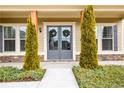 Up close shot of the home's entryway, featuring a double door design and manicured shrubbery at 411 Ridgeway Ln, Canton, GA 30114