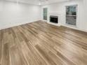 An empty living room featuring a fireplace, large windows and light wood flooring at 4409 Idlewood Ln, Tucker, GA 30084