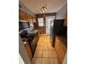 Compact kitchen with stainless steel appliances, wood cabinets, and tiled floor at 571 Formwalt Sw St # 7, Atlanta, GA 30312