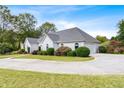 Side view of a one-story home showing the circular driveway, manicured lawn, landscaping, and attached garage at 1453 Reagan Cir, Conyers, GA 30012