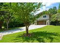 Landscaped front yard leads up to the home with a large driveway and modern features at 2116 Strasburg Ct, Dunwoody, GA 30338