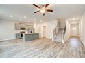 Open-concept living room featuring stairs to upper level and kitchen with large center island at 324 Shine Dr, Stockbridge, GA 30281