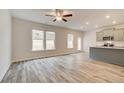 Open-concept living room featuring a ceiling fan, a seamless flow into the kitchen, and ample natural light at 324 Shine Dr, Stockbridge, GA 30281
