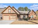 Charming brick home featuring a two-car garage and a neatly maintained front yard with mature landscaping at 1115 Harvest Brook Ne Way, Lawrenceville, GA 30043