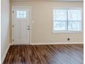 Bright room with hardwood floors, a large window, and a white paneled front door at 2504 Brentwood Rd, Decatur, GA 30032