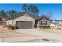 View of a single Gathering home with a two car garage and well-kept yard at 8125 Berrywood Se Ct, Covington, GA 30014