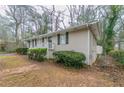 Side view of ranch style home showing painted brick, dark shutters, and fenced yard at 2024 Rosewood Rd, Decatur, GA 30032