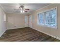 Light-filled living room featuring dark wood floors, ceiling fan, and view of front yard at 2024 Rosewood Rd, Decatur, GA 30032
