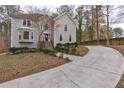Two-story home with an inviting driveway and a beautifully landscaped front yard surrounded by mature trees at 3938 Belle Glade Ct, Snellville, GA 30039