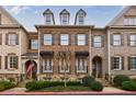 Charming brick townhome with black awnings, dormer windows, and manicured landscaping at 2368 Saint Davids Nw Sq # 4, Kennesaw, GA 30152