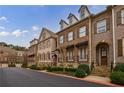 Brick townhomes with dormer windows, awnings, stone steps, and manicured landscaping at 2368 Saint Davids Nw Sq # 4, Kennesaw, GA 30152