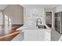 Modern white kitchen boasts sleek quartz countertops, stainless steel appliances, and hardwood floors at 3017 Lana Ln, Marietta, GA 30066