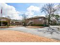 Brick complex exterior showing two-story building with stairs leading to upper floor and manicured landscape at 475 Mount Vernon Ne Hwy # A-102, Sandy Springs, GA 30328