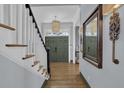 Elegant foyer showcasing hardwood floors, a staircase, decorative mirror, and stylish chandelier at 1421 Hedgewood Nw Ln, Kennesaw, GA 30152