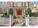Inviting front entrance with a red door, stone steps, decorative columns, and manicured shrubs at 1421 Hedgewood Nw Ln, Kennesaw, GA 30152