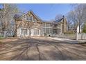 Spacious home featuring a stone exterior, a screened porch, a basketball area, and a long driveway at 1421 Hedgewood Nw Ln, Kennesaw, GA 30152