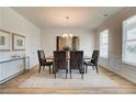 Formal dining room with a modern chandelier, large window, and elegant decor at 1856 Kingsmere Run Dr, Loganville, GA 30052