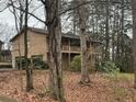 Tan two-story home featuring a deck, swing set, and wooded backyard, in a lush leafy neighborhood at 25 Chestnut Ridge Ne Dr, Cartersville, GA 30121