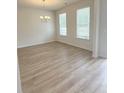 Sun-drenched dining area featuring vinyl flooring, a modern chandelier, and plenty of natural light at 1847 Kingsmere Run Dr, Loganville, GA 30052