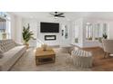 Cozy living room with fireplace, ceiling fan, hardwood floors, and neutral decor at 106 Cottage Gate Ln, Roswell, GA 30076