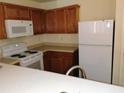 Compact kitchen featuring white appliances and ample wooden cabinetry at 770 Parkway Rd, Union City, GA 30291