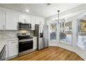 Eat-in kitchen featuring stainless steel appliances, marble backsplash, and lots of natural light at 2977 Heritage Villas Dr, Lithonia, GA 30038