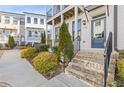 Charming townhome exterior featuring brick steps, manicured landscaping, and a covered porch at 1756 Morningtide Ne Ln, Atlanta, GA 30324