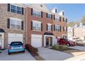 Charming brick townhome with a well-manicured front yard and driveway with cars at 3782 Chattahoochee Summit Se Dr, Atlanta, GA 30339