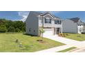 View of a new gray two-story home on a grassy lot with a brick-accented facade at 300 Halibut Circle Cir, Covington, GA 30016