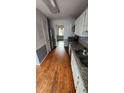 Galley-style kitchen featuring stainless steel appliances, white cabinets, and hardwood floors at 465 Salem Woods Se Dr, Marietta, GA 30067