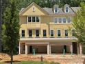Beautiful new construction townhome with a yellow facade, brick accents, and a convenient attached garage at 1983 American Way # 27, Kennesaw, GA 30144