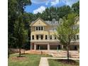 Exterior view of a new townhome featuring a yellow exterior, a garage, and an inviting front lawn at 1983 American Way # 27, Kennesaw, GA 30144