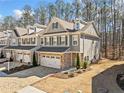 Townhome showcasing landscaped front yard, two-car garage, and classic design elements at 495 Duval Dr, Alpharetta, GA 30009