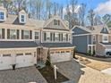 Classic townhome with a brick driveway, neutral siding, and dark shutters at 495 Duval Dr, Alpharetta, GA 30009