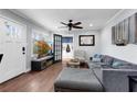 Comfortable living room with a large window, wood floors, a gray couch, and a modern ceiling fan at 681 Home Se Ave, Atlanta, GA 30312