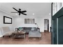 Inviting living room featuring hardwood floors, a cozy gray sofa, modern ceiling fan and natural light at 681 Home Se Ave, Atlanta, GA 30312