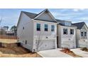 Side view of a townhouse showing painted brick and a two-car garage at 1327 Fern Ridge Ct # 27, Norcross, GA 30093