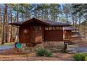 Cozy home showcasing unique architectural wood details, stone accents, and beautiful landscaping at 2513 Overlake Ln, Stockbridge, GA 30281