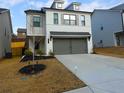 Charming two-story home with a white brick facade, grey shutters, a two-car garage and a well-manicured lawn at 51 Station Overlook Way, Auburn, GA 30011
