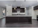 Spacious kitchen island with granite countertop, stainless steel appliances and dark wood floors at 1255 Windmill Pkwy, Cumming, GA 30041