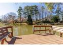 Wooden dock with built-in benches offering a tranquil view of the calm lake and surrounding greenery at 2143 Bogans Lake Path, Dunwoody, GA 30338