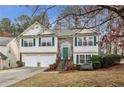 Charming two-story home boasts a two-car garage, stone accents, green shutters, and a neatly landscaped front yard at 1559 Hillary Cove Ct, Lawrenceville, GA 30043